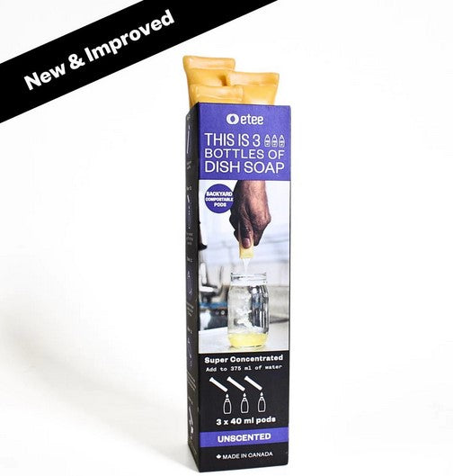 Close-up of clear, plastic dish soap concentrate bottle showing bright green liquid and textured label with product details.