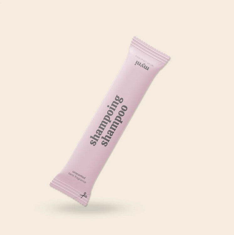 Close-up of Myni Shampoo label highlighting handcrafted, organic ingredients with natural farm-raised herbs on the textured