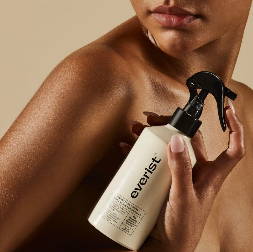 Close-up of the exfoliating textured body scrub in a sleek black jar with silver lid, showing grainy surface detail and