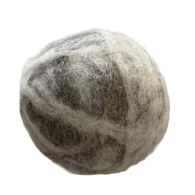 Close-up of three XL wool dryer balls showcasing their textured, soft surface and natural off-white color from a slightly