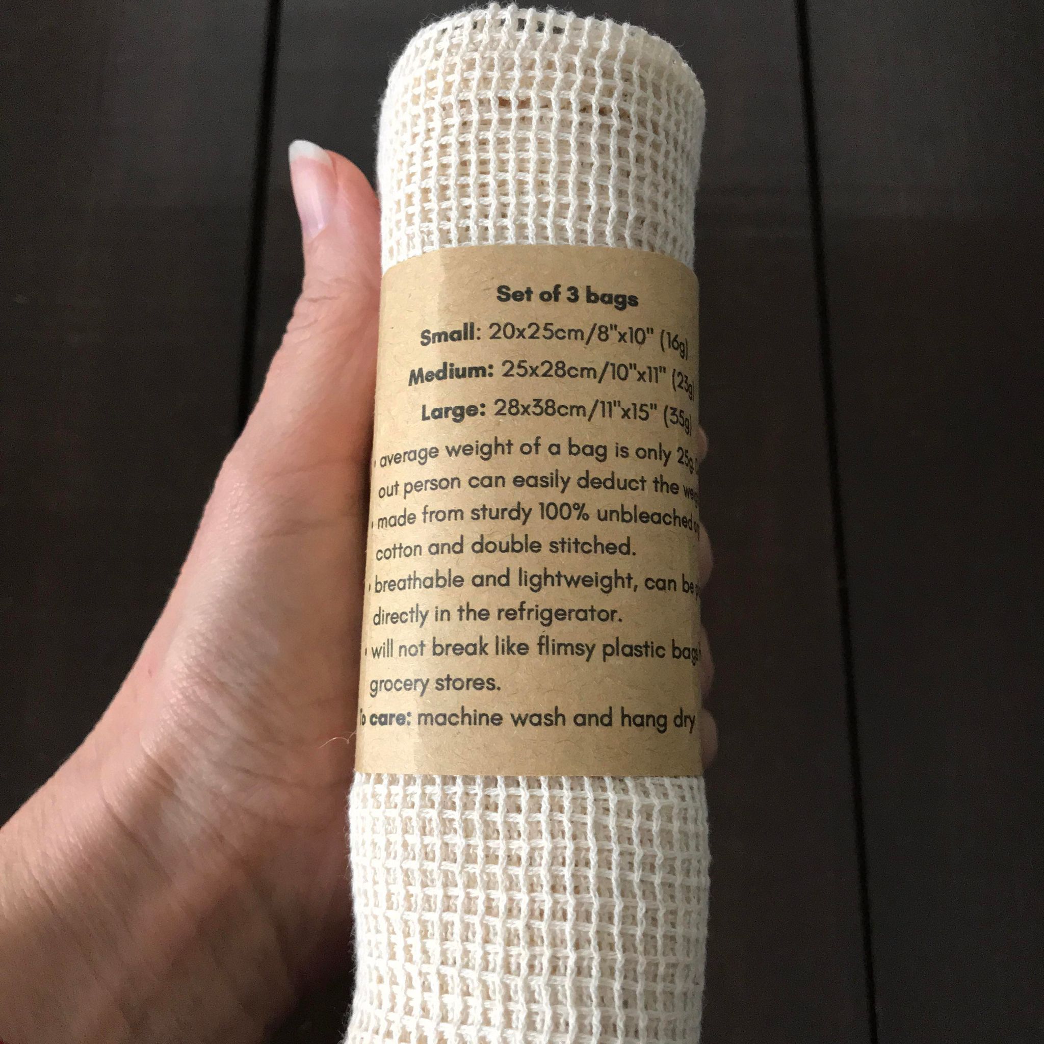 Close-up of colorful reusable organic cotton produce bags with visible drawstring detail and textured fabric surface.