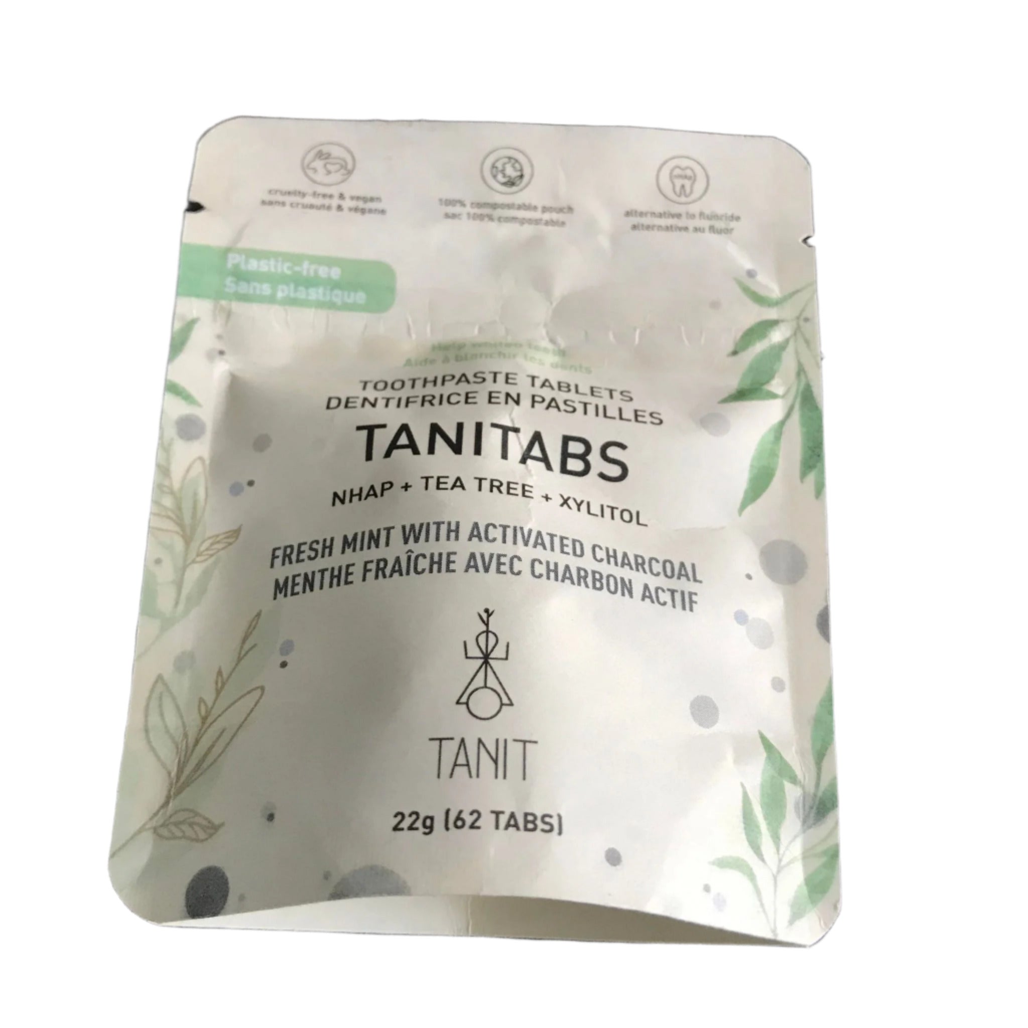 Close-up of the activated charcoal and mint flavored tablets inside a clear glass jar with metallic lid, showcasing