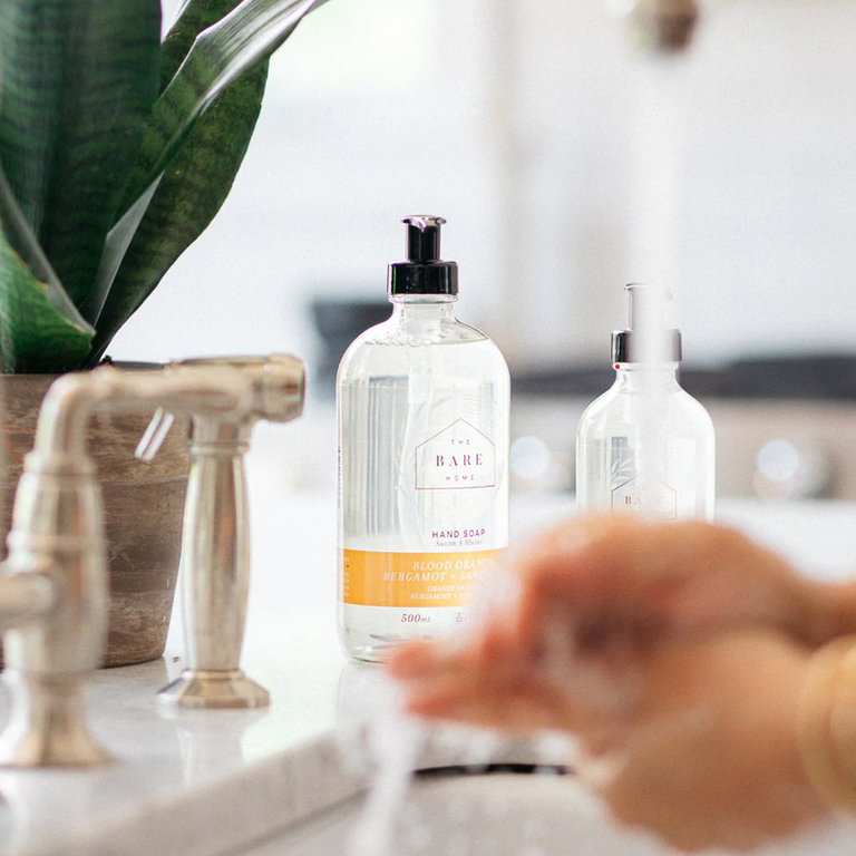 Close-up of the hand soap’s textured surface with a partial view of the elegant bottle label against a neutral background.