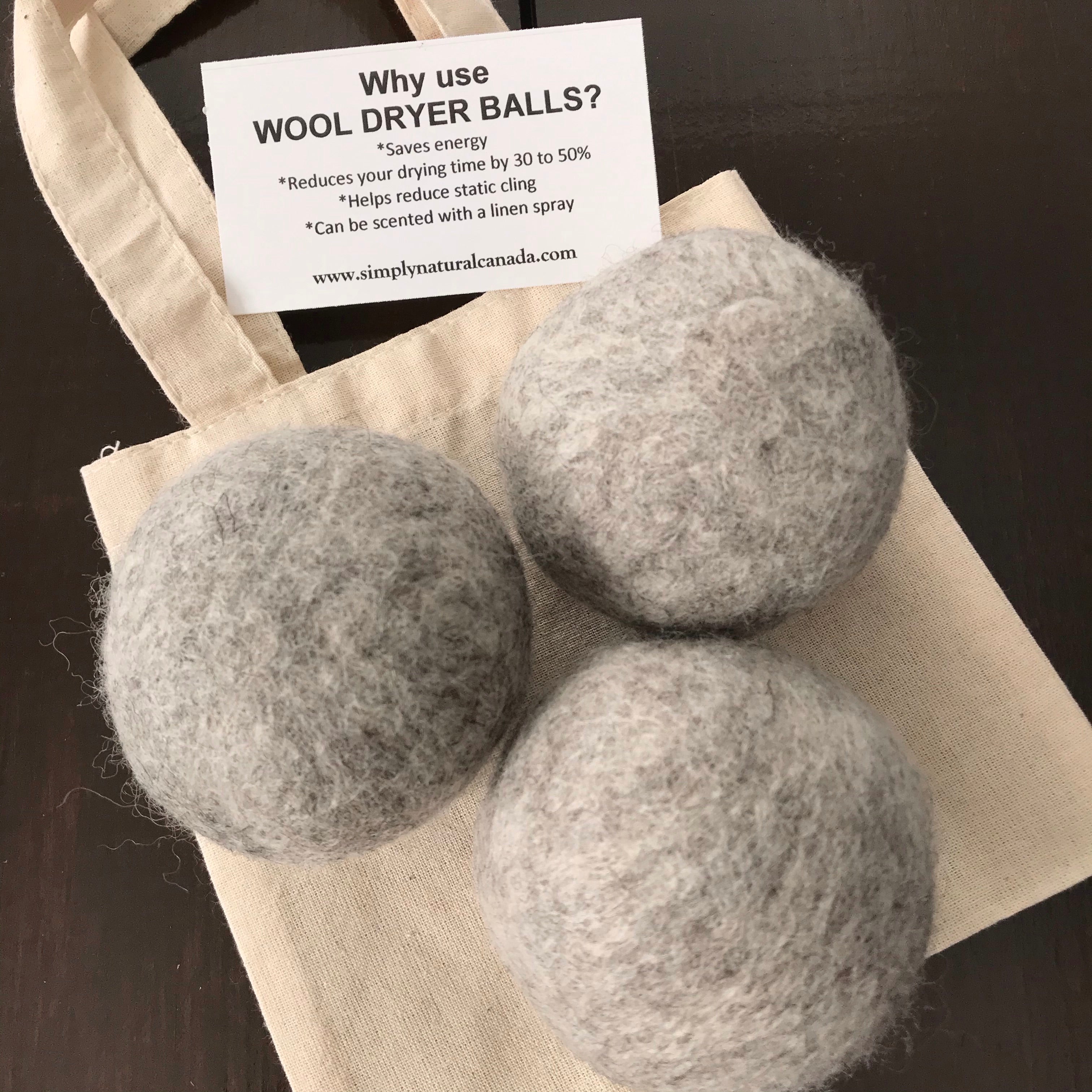Close-up of three natural wool dryer balls revealing textured surfaces and subtle off-white tones, showcasing their