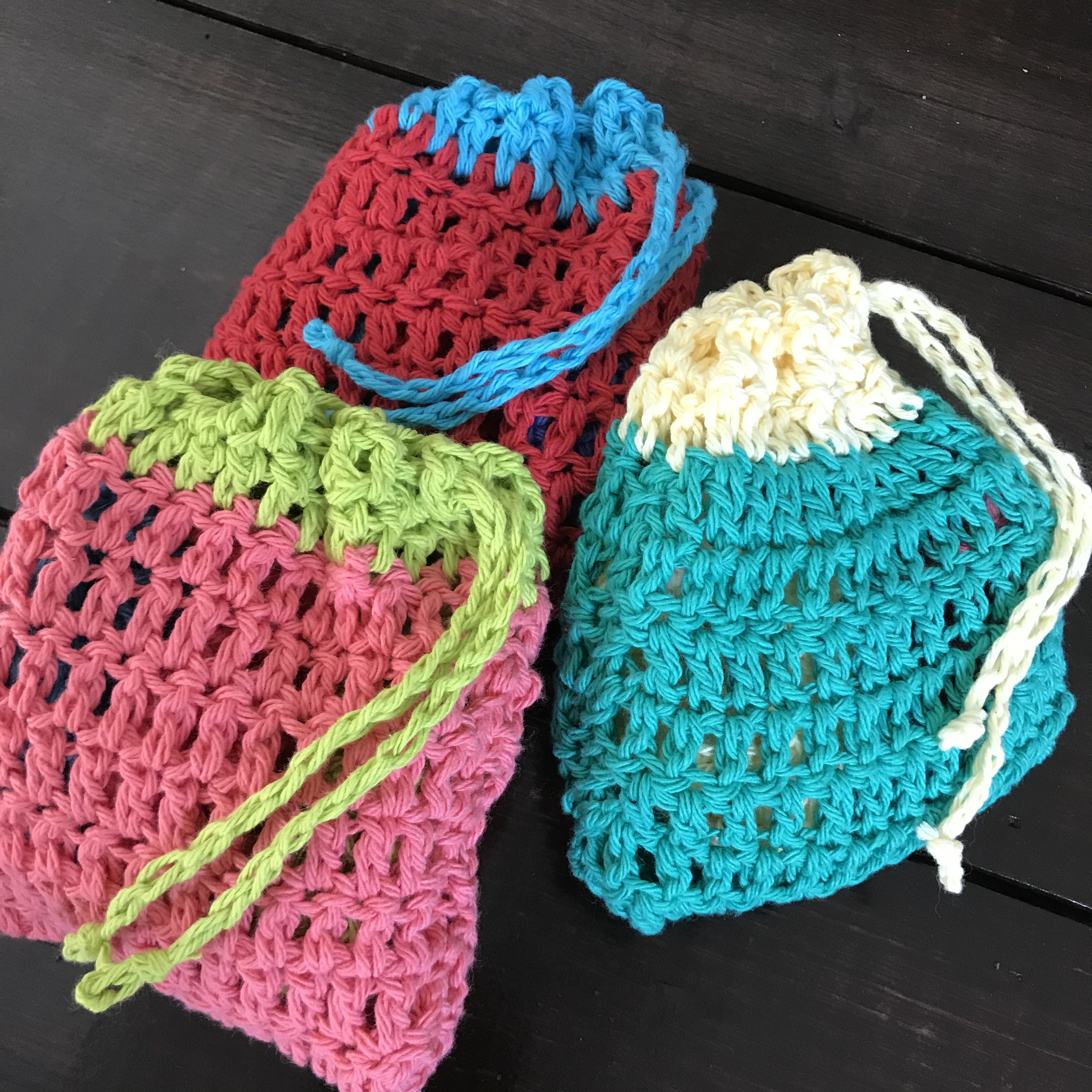 Close-up of crocheted water balloons showing textured, colorful yarn stitches with tiny hanging loop details for filling