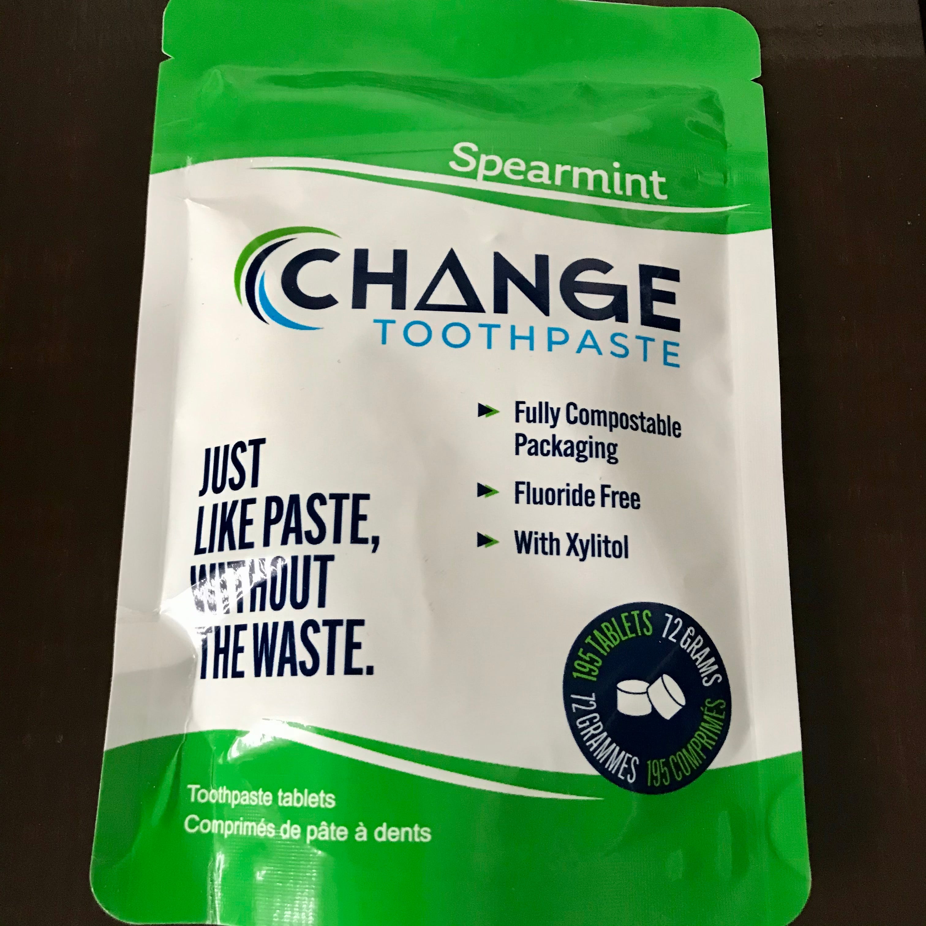 Close-up of spearmint-flavored toothpaste tablet packaging with clear labeling and textured surface on a white background