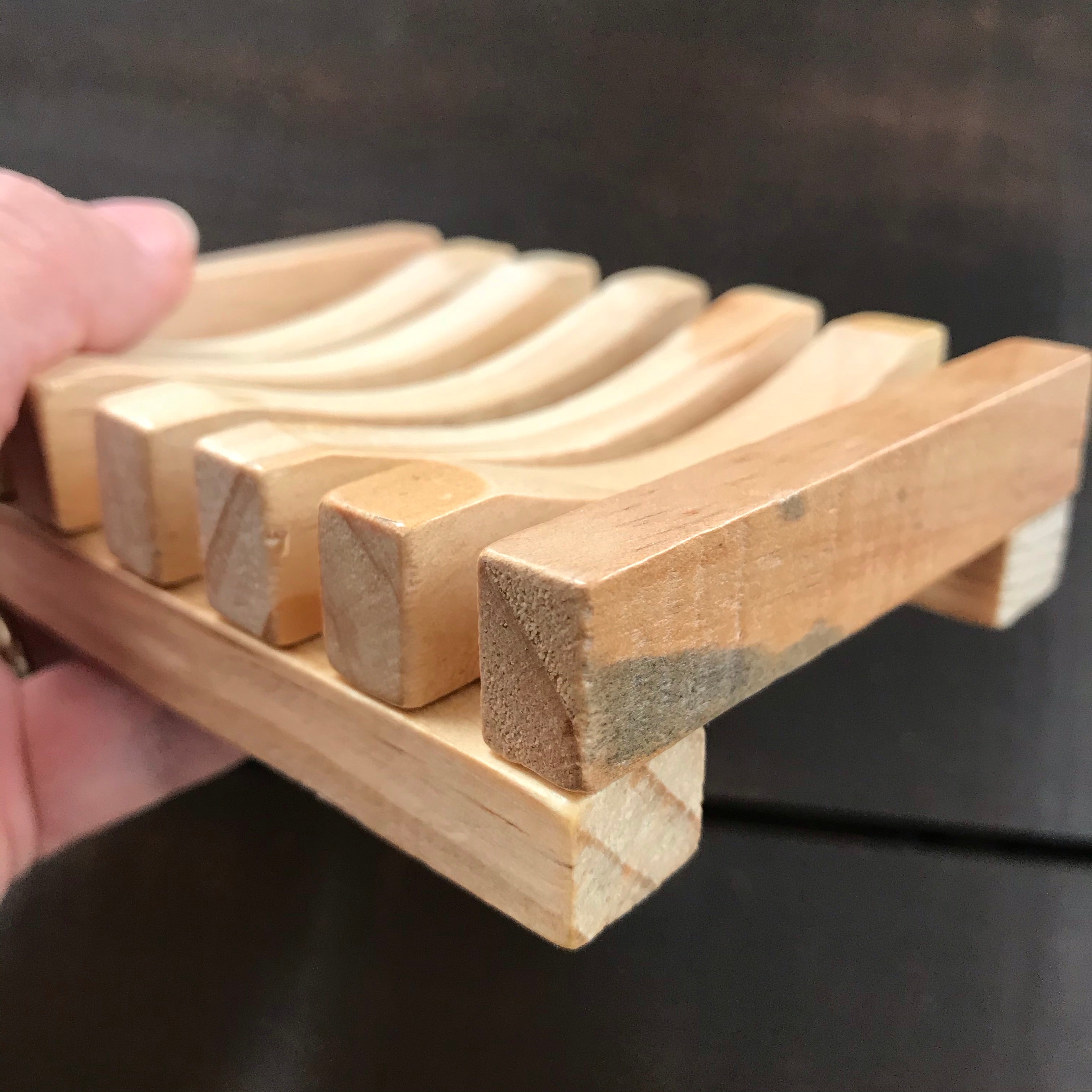 Close-up of the slatted wood surface revealing natural grain, smooth finish, and precise evenly spaced slats for drainage.