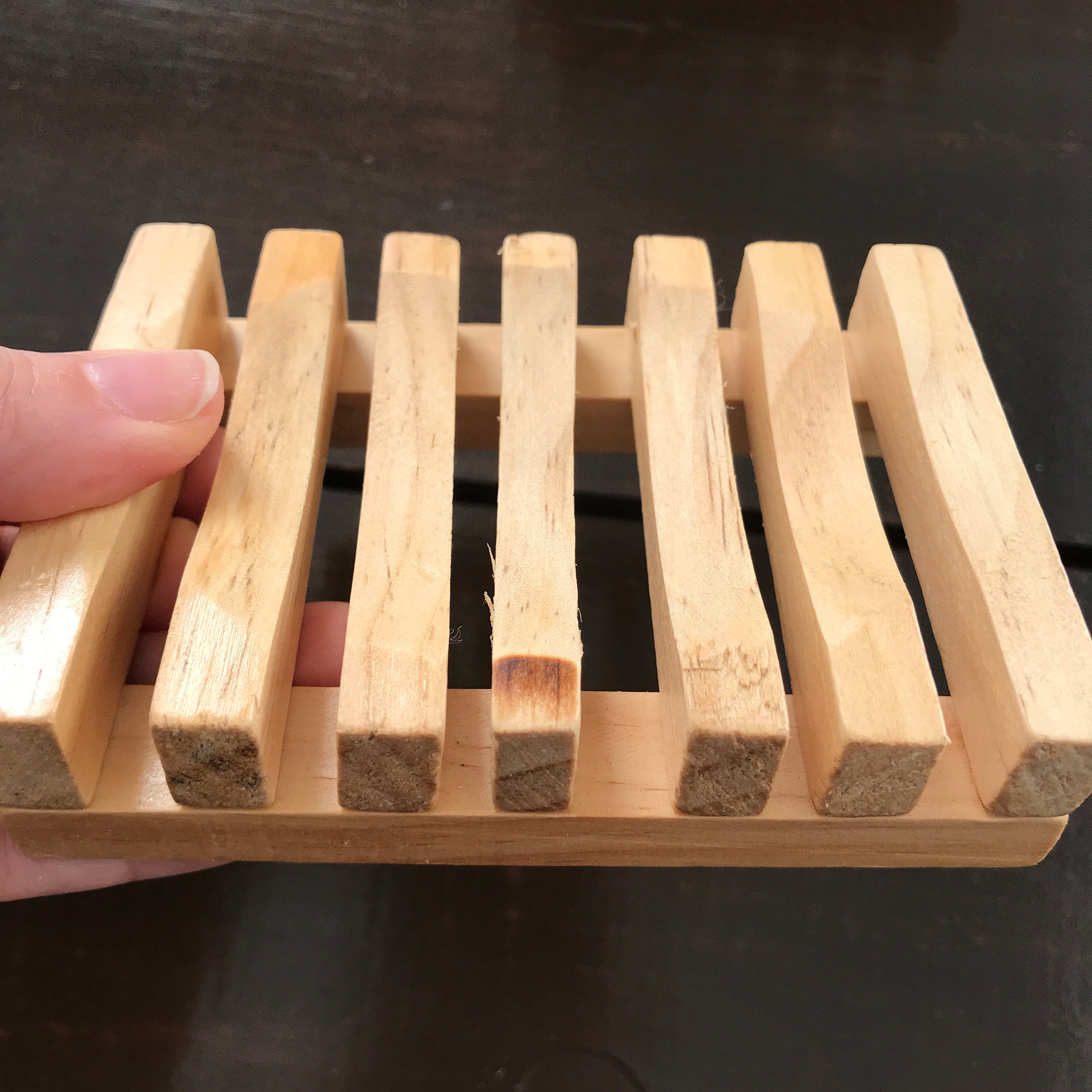 Close-up of the slatted wood soap dish showcasing textured surface and precise evenly spaced slats for drainage
