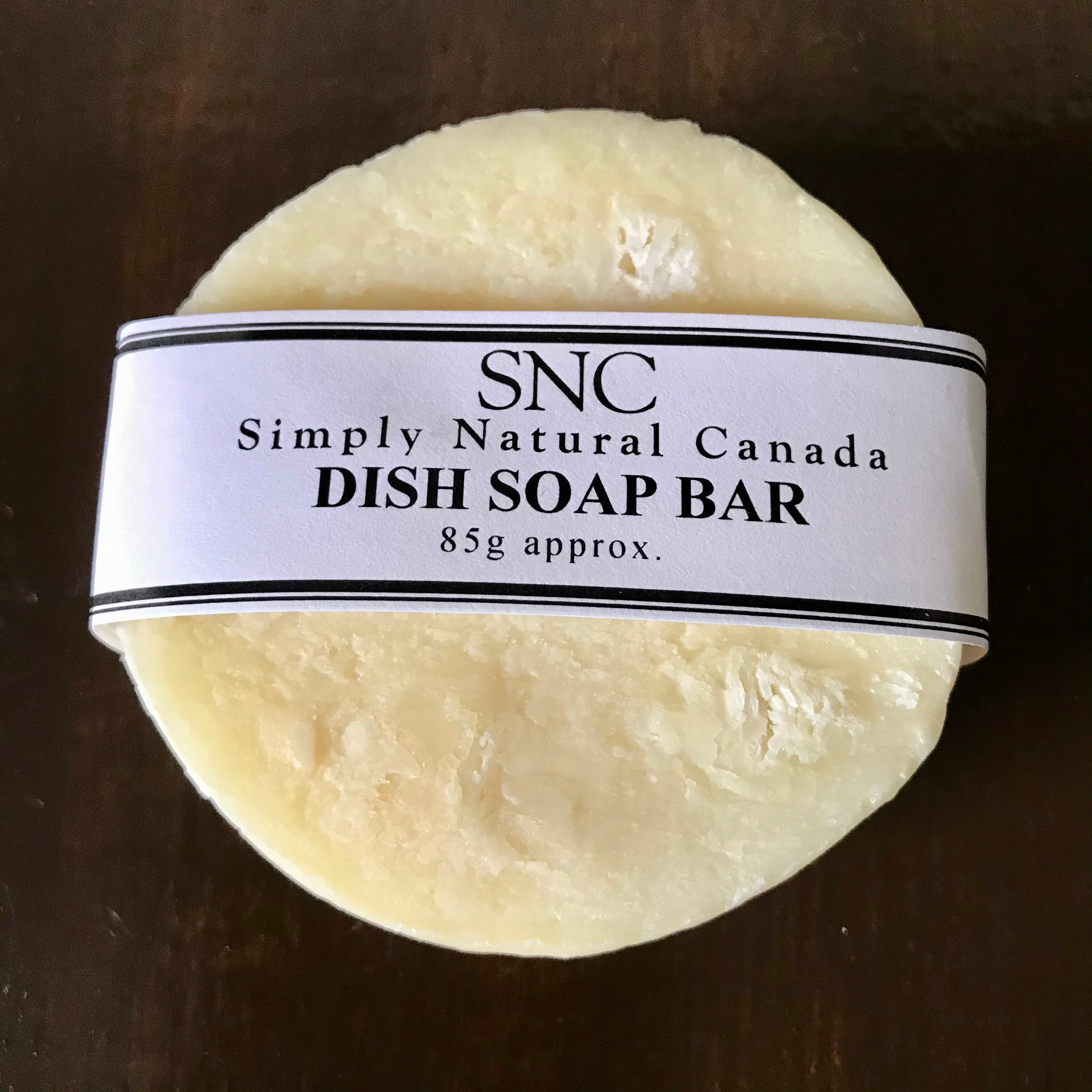 Close-up of the textured, pale beige soap bar with visible natural plant fiber exfoliants embedded on its surface.