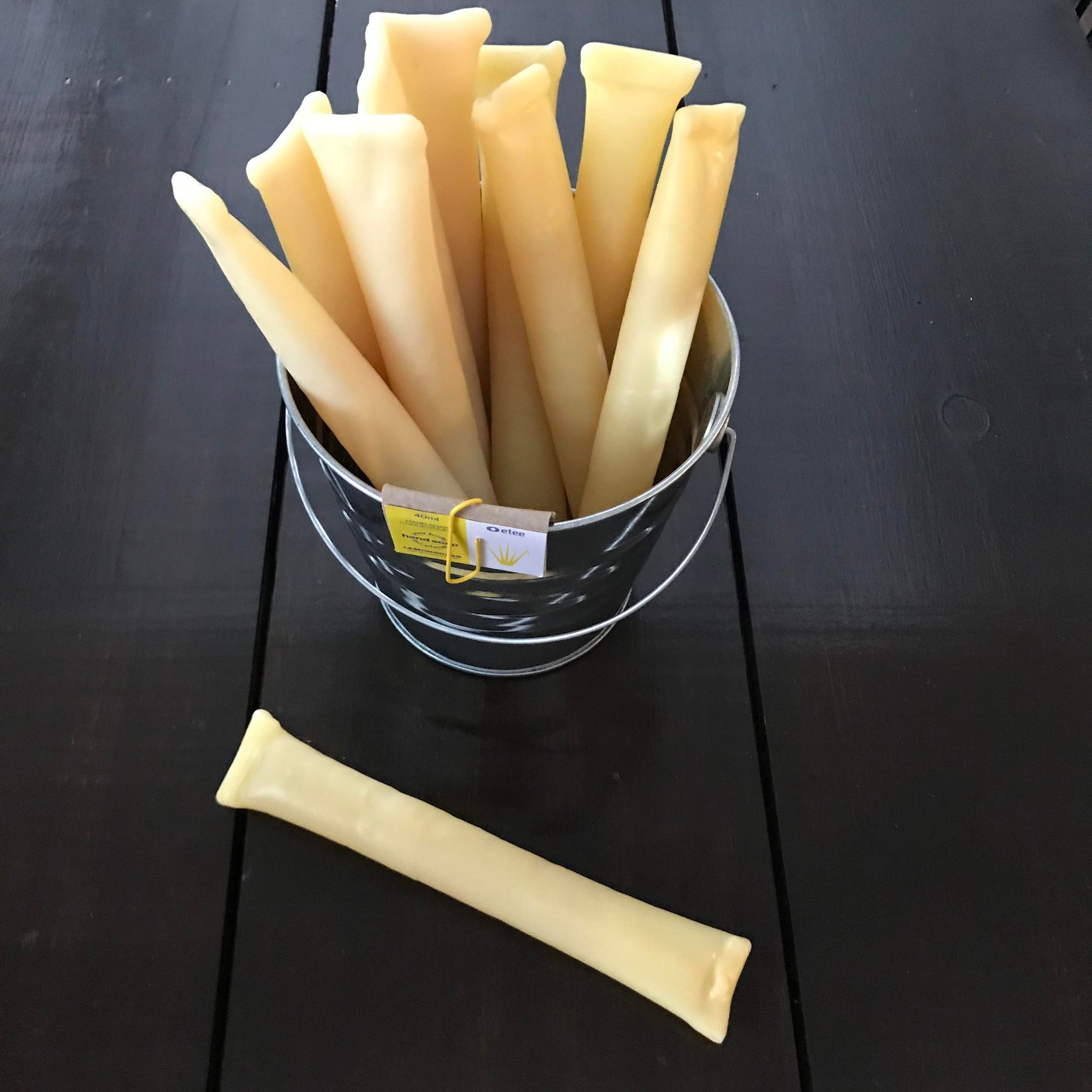 Close-up of clear lemongrass extract in frosted glass bottle with textured label and botanical illustrations visible.
