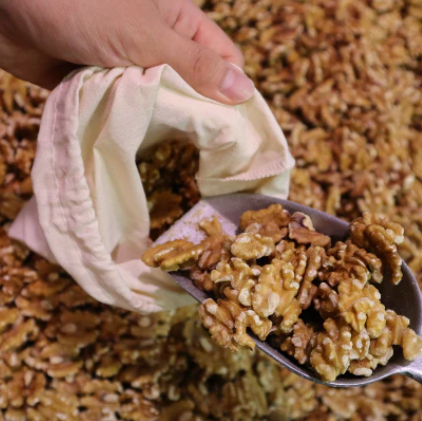 Close-up of organic cotton muslin bag’s textured weave and hand-stitched drawstring closure for fresh storage.