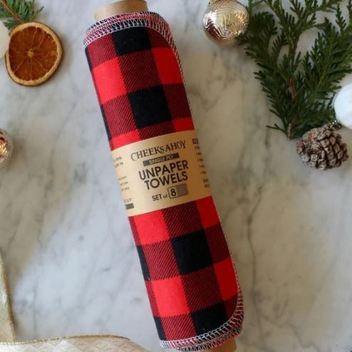 Close-up of red and black reusable non-paper towel edges with visible stitched seams and textured fabric surface.