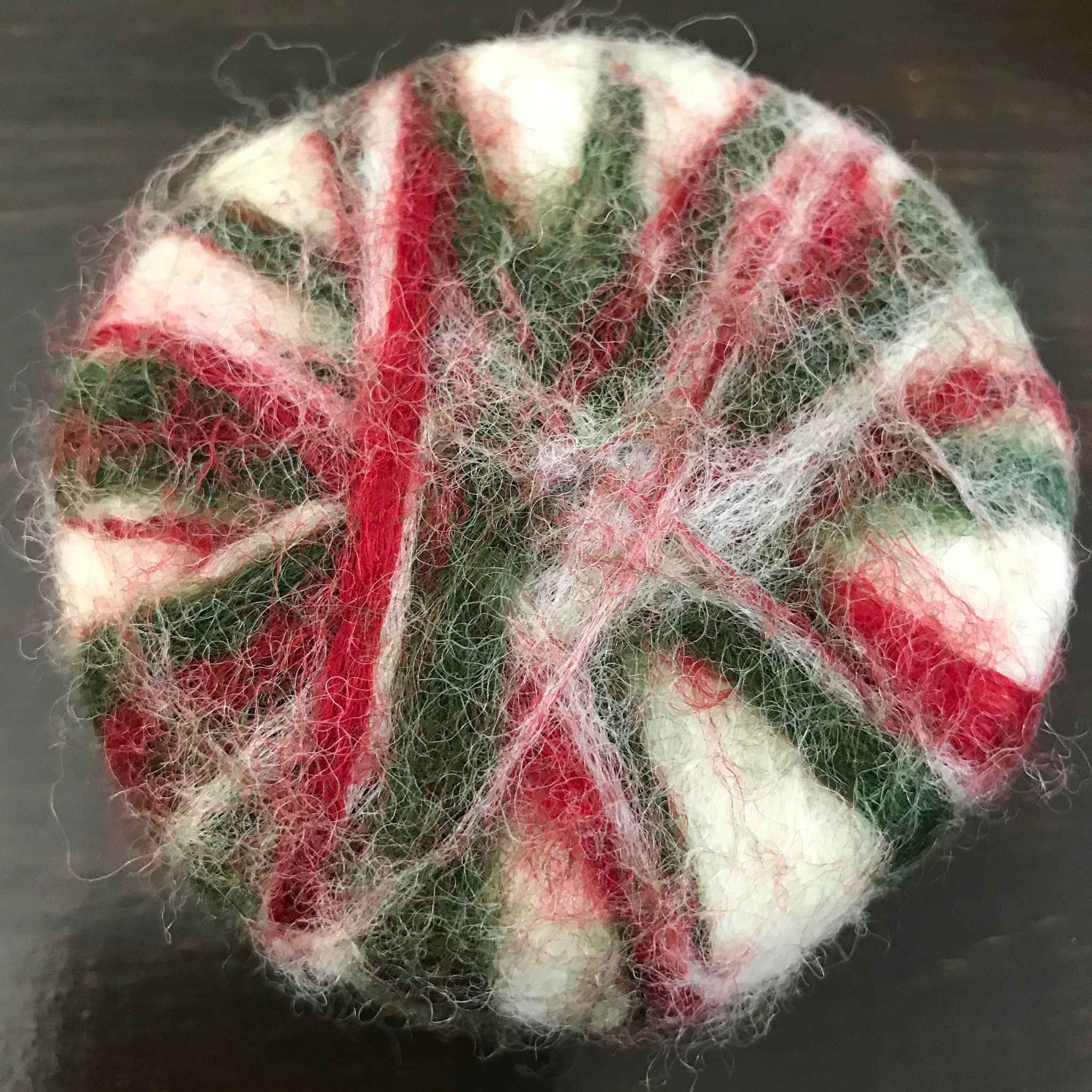 Close-up of felted Christmas soap’s textured surface highlighting colorful fiber details and intricate needlework