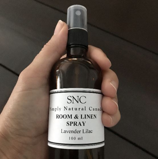 Close-up of the lavender-scented spray bottle’s textured glass surface and silver spray nozzle, showcasing elegant detailing.