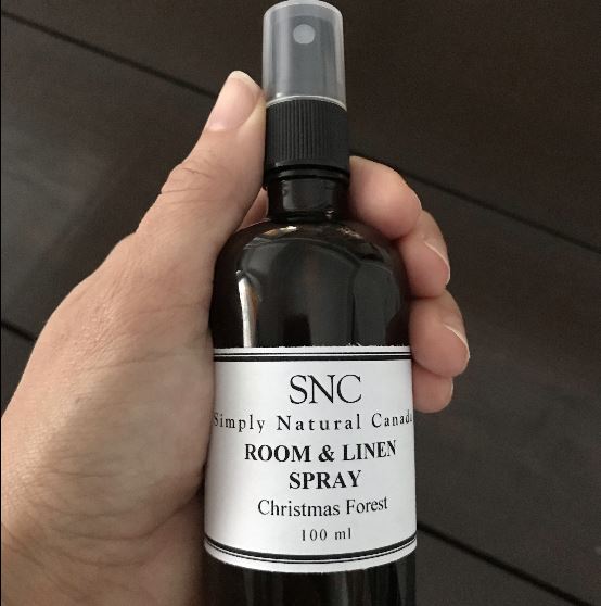 Close-up of the Room and Linen Spray spray nozzle with clear white cap and subtle textured glass bottle surface visible from
