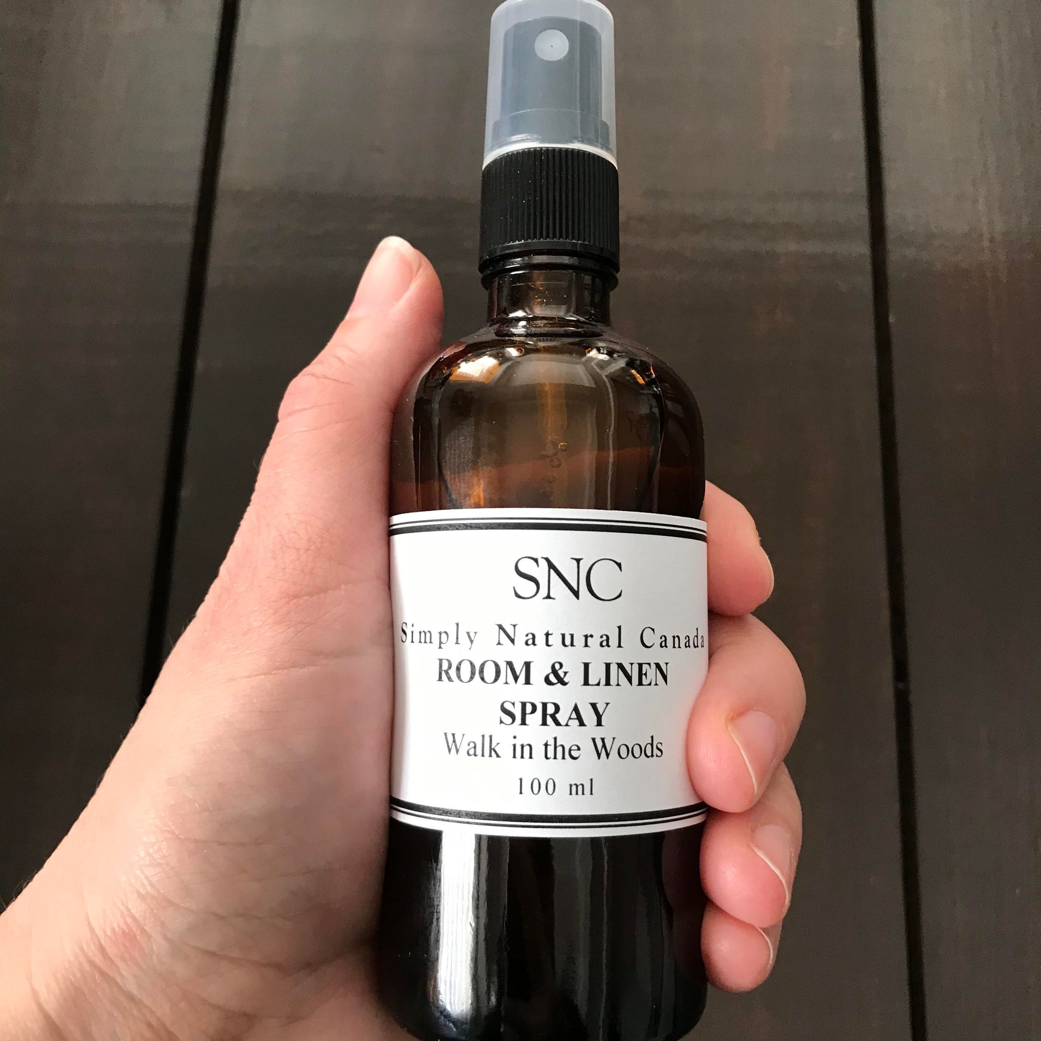 Close-up of the room and linen spray bottle’s textured matte surface with a lavender-colored cap and minimal branding label