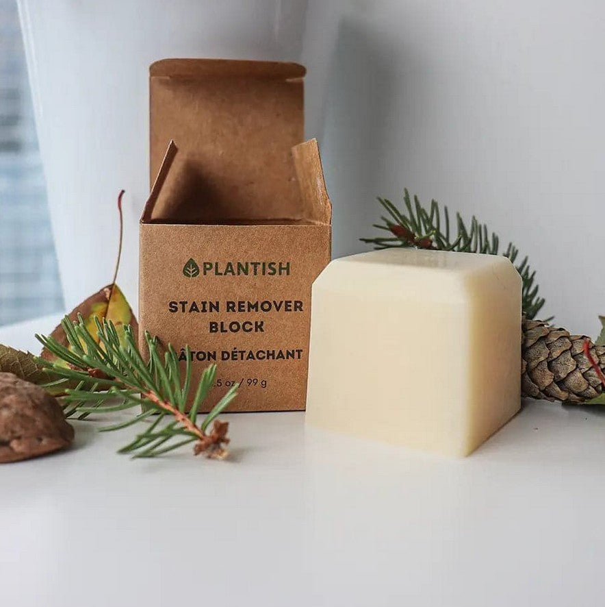 Close-up of the Plantish Stain Remover Block showing textured white soap embedded in a clear plastic casing with a blue