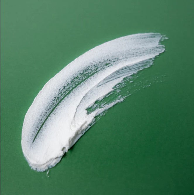 Clear, un scented balm being gently applied with fingers to baby's clean skin, showcasing smooth, creamy texture and easy