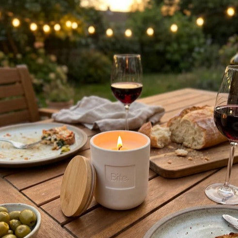Bite Outdoor Candle burning on outdoor patio table during summer evening dinner with lemon eucalyptus fragrance and ambient candlelight