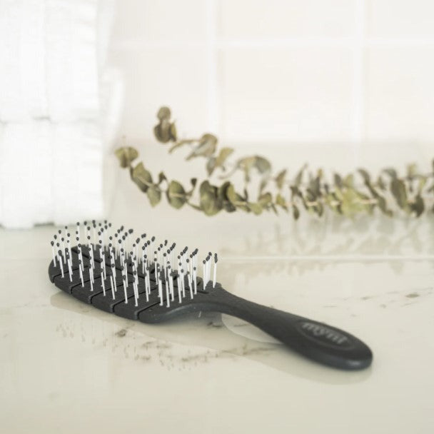 Close-up of the Myni Wheat Straw Hair Brush handle showcasing smooth, eco-friendly texture and natural color details.
