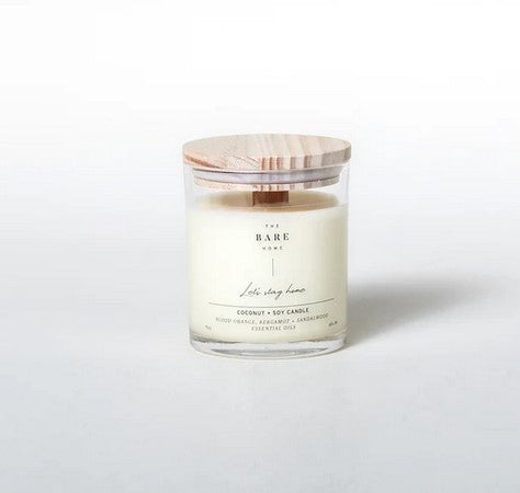 Close-up of the candle’s textured frosted glass jar with a subtle amber hue, highlighting the engraved logo and smooth