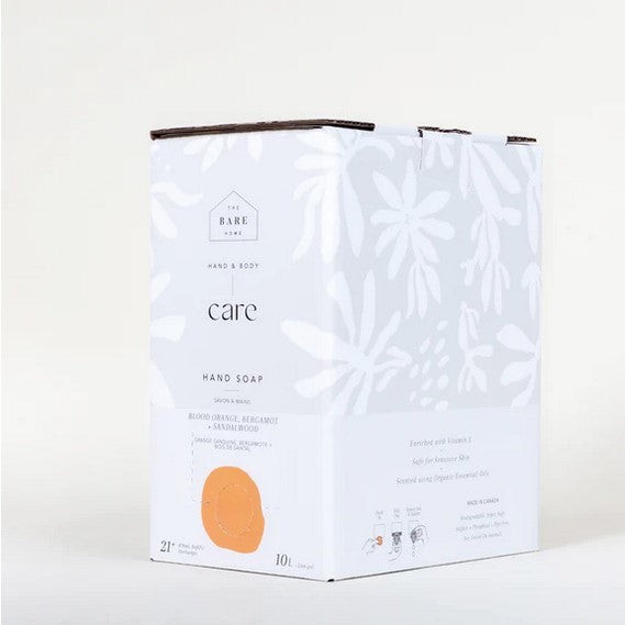 Close-up of the textured embossed label on the Blood Orange, Bergamot, and Sandalwood hand soap bottle cap showing vibrant