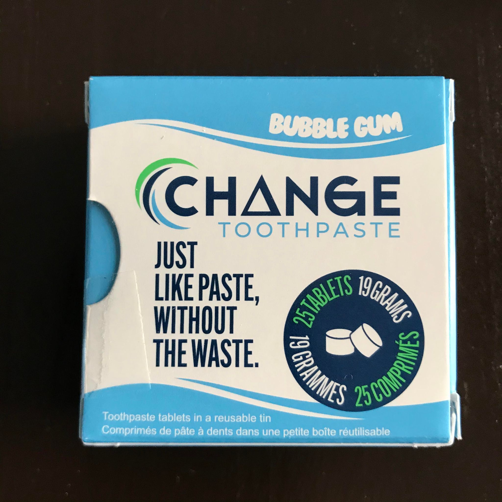 Close-up of bubblegum-flavored toothpaste tablets arranged in a clear glass jar, highlighting their rounded shape and