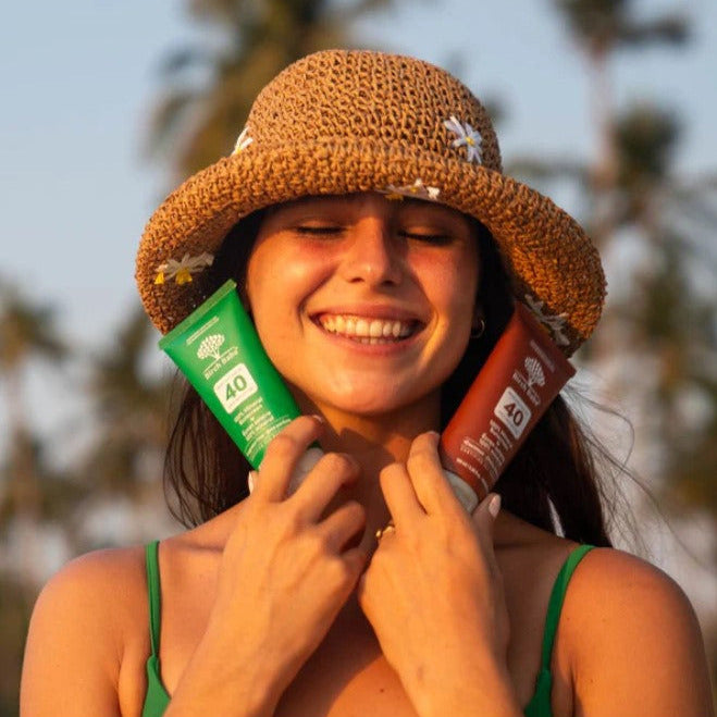 Woman holding Birch Babe Mineral Sunscreen SPF 40 in fragrance-free and coconut formulas – Canadian-made natural mineral sunscreens in compostable tubes.