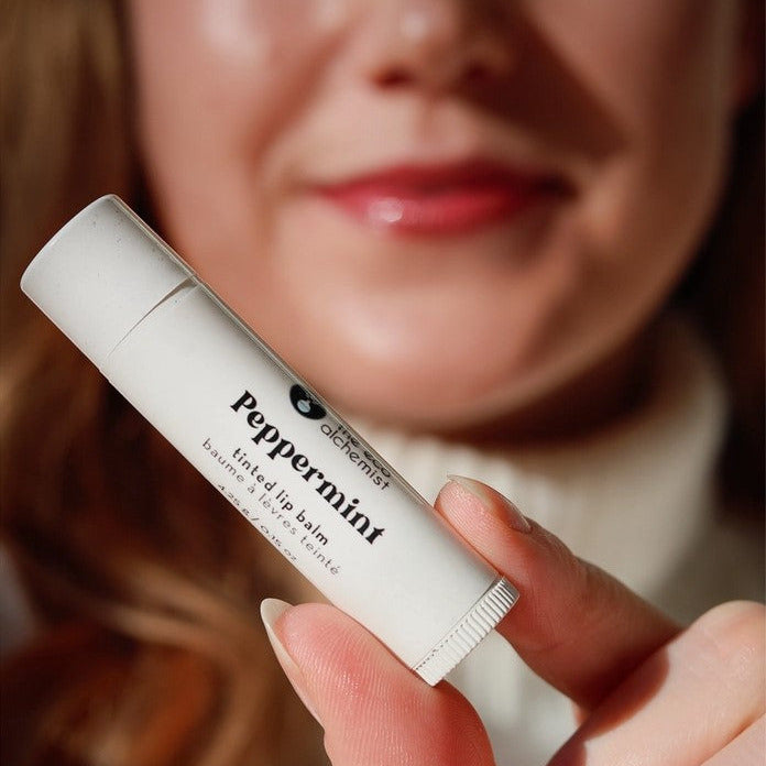 Canadian made compostable peppermint tinted lip balm held in hand