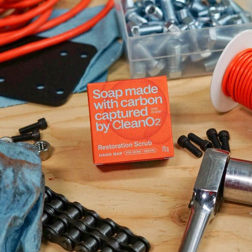 CleanO2 Restoration Scrub Hand Bar in workshop setting surrounded by tools, bolts and cables, heavy-duty Canadian hand soap for grease and grime
