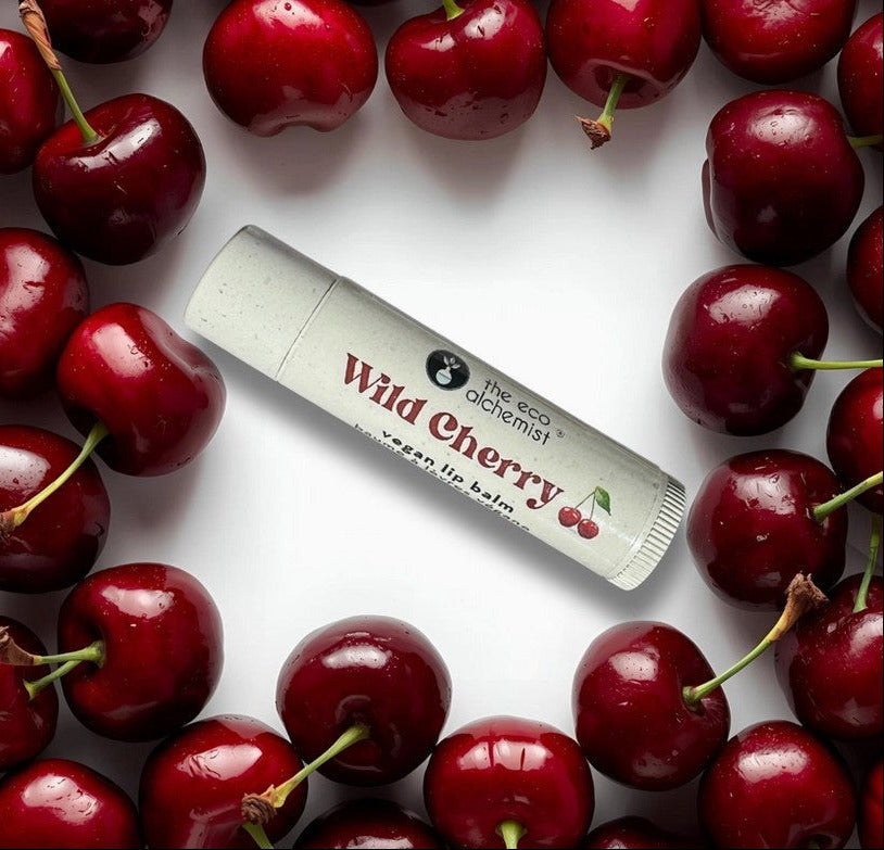 Canadian made wild cherry vegan lip balm with fresh cherries background
