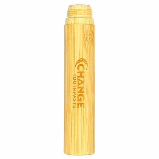 Close-up of the bamboo toothbrush handle’s textured, matte surface with engraved logo and vibrant green bristles at the tip.