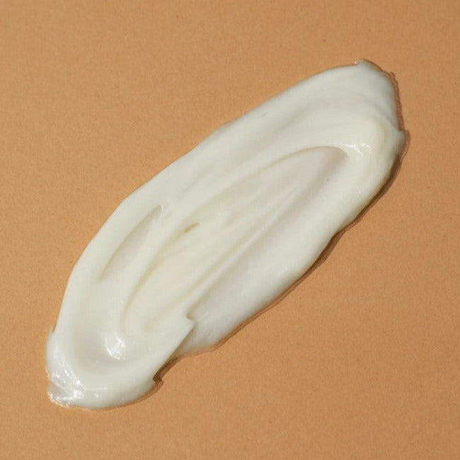 Close-up of the Body Quench - Chantilly lotion tube displaying fresh floral scent notes and smooth, hydrating texture for