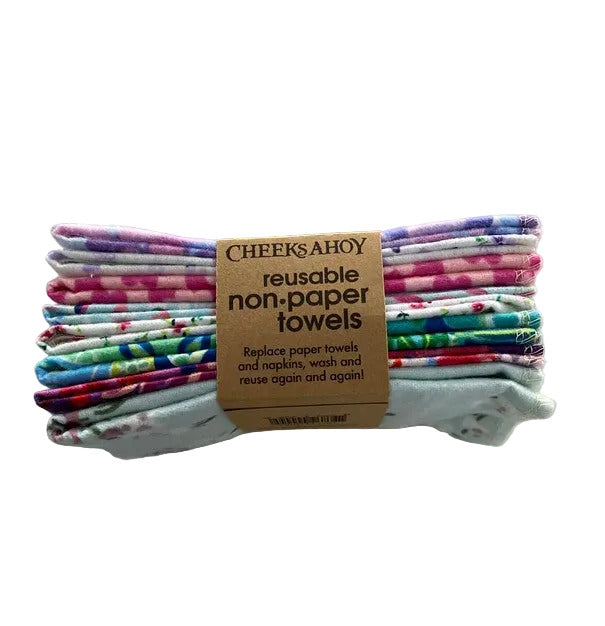 Stack of colourful reusable non-paper towels in a floral pattern with a brown kraft label made in canada shown on a white surface