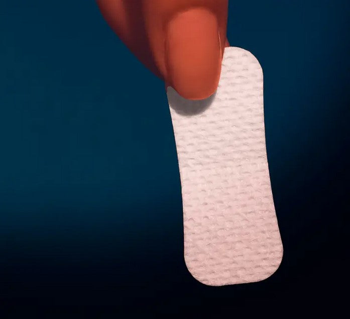 Close-up of the white mouth tape's textured adhesive surface showing tiny perforations and flexible design for comfortable