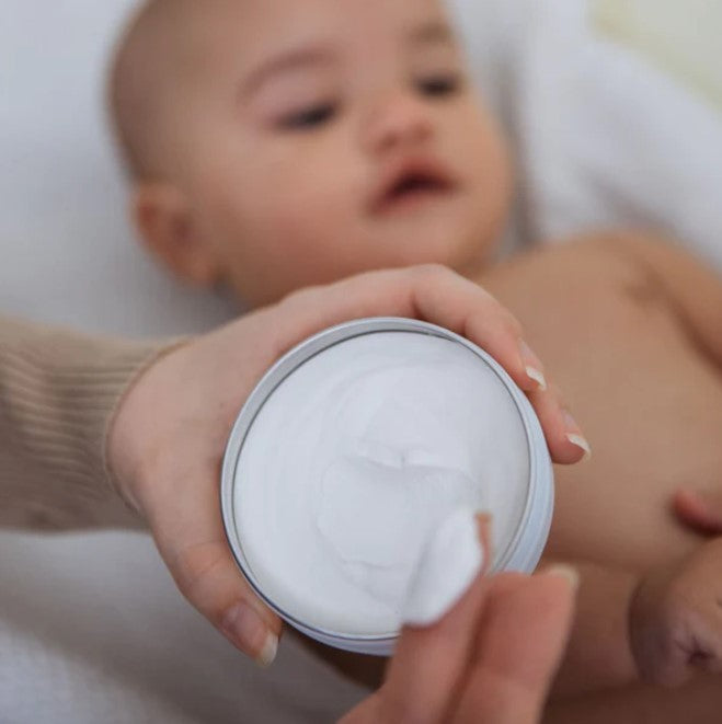 Close-up of Birch Baby Diaper Balm's creamy, smooth texture on fingertips, highlighting gentle, skin-nourishing formula and