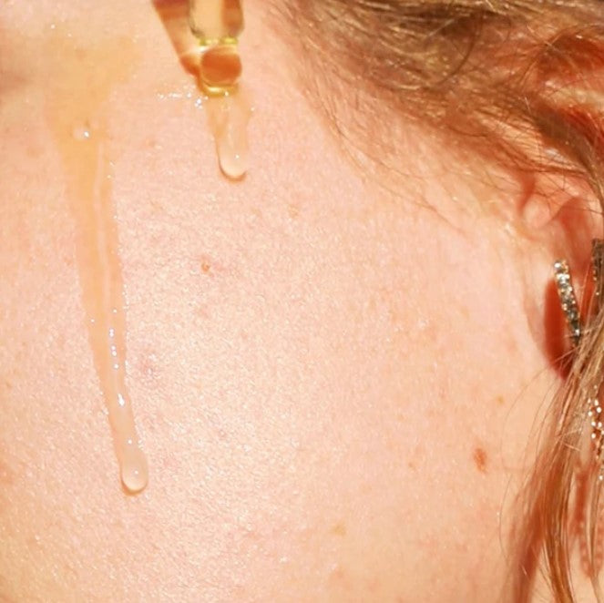 Close-up of Double Duty Face Oil bottle showing textured dropper cap and soft amber hue, highlighting elegant packaging