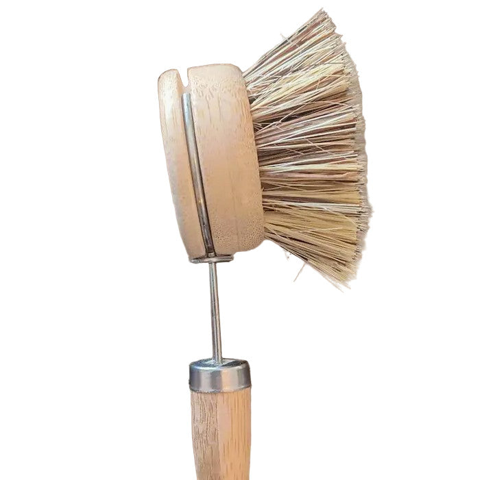 Close-up of the compostable brush handle’s textured bamboo finish and ergonomic grip design from an angled top view.