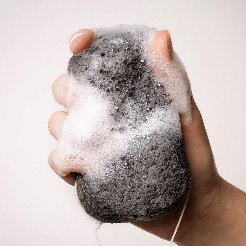 Close-up of the black konjac sponge’s textured surface highlighting its porous, natural finish for gentle exfoliation