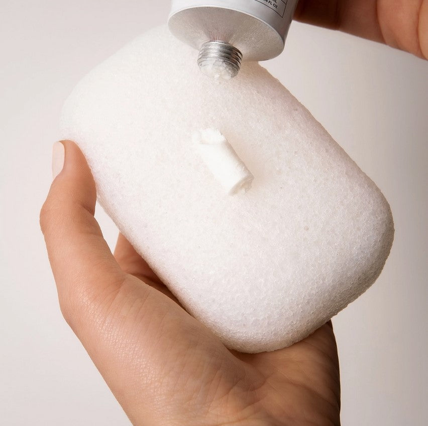 Close-up of textured konjac sponge surface showing porous, fibrous details in white, highlighting natural material and