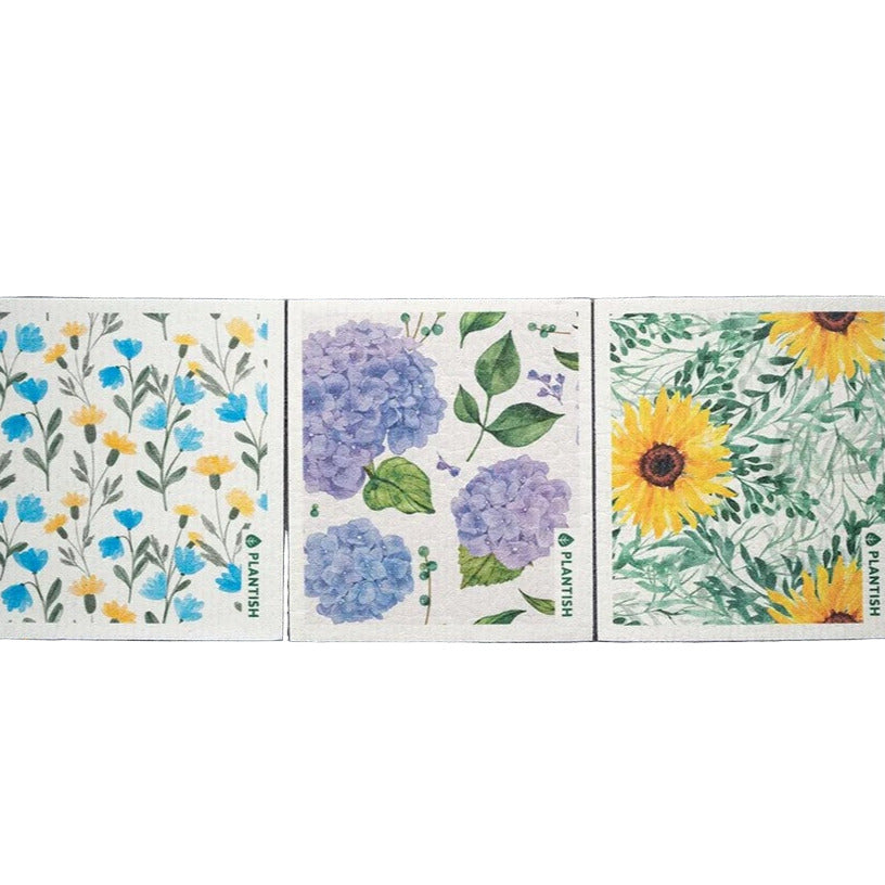 Close-up of the Floral Bursts Swedish Sponge Cloth's vibrant print detail against a white background in a flat lay view