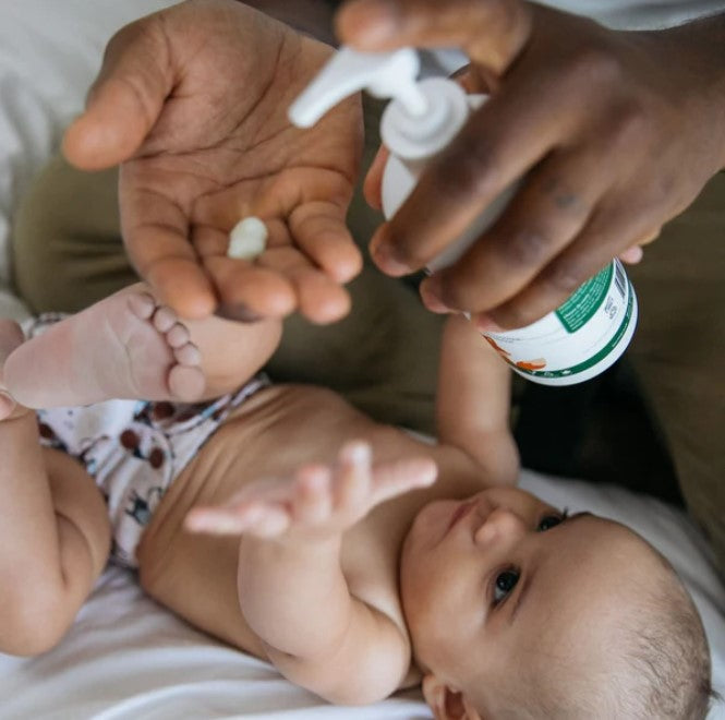 Close-up of Birch Baby Nourishing Lotion tube showing detailed ingredient label and soft, matte texture on skin-like