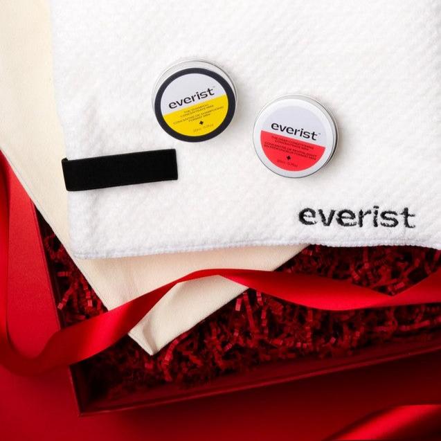 Close-up of the travel-sized bottles showcasing natural ingredient labels and textured caps in the set's compact packaging.