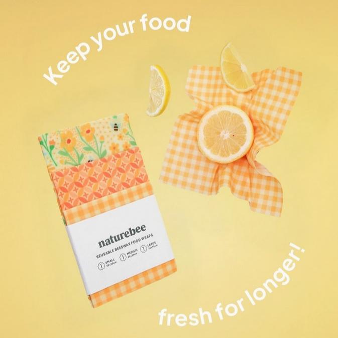 Close-up of yellow beeswax wraps showcasing textured, hand-crafted patterns and vibrant organic botanical designs from an