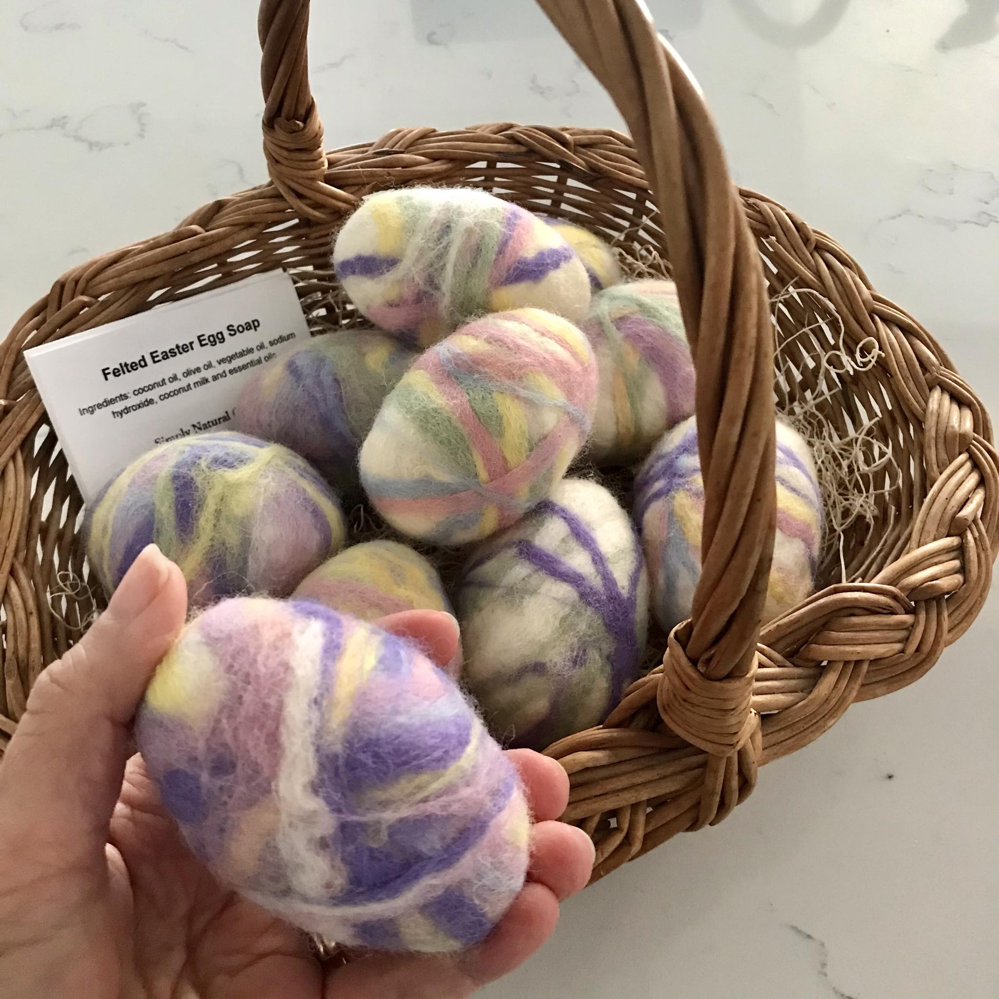 Close-up of the felted soap's textured surface highlighting intricate wool fibers and colorful Easter egg design detail.