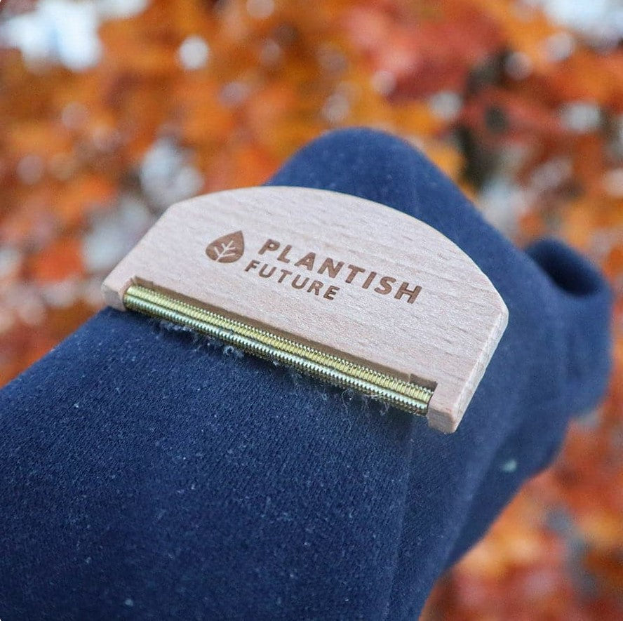 Close-up of the Plantish Wooden Lint Remover’s textured, honey-toned bamboo surface showing fine fiber details and natural