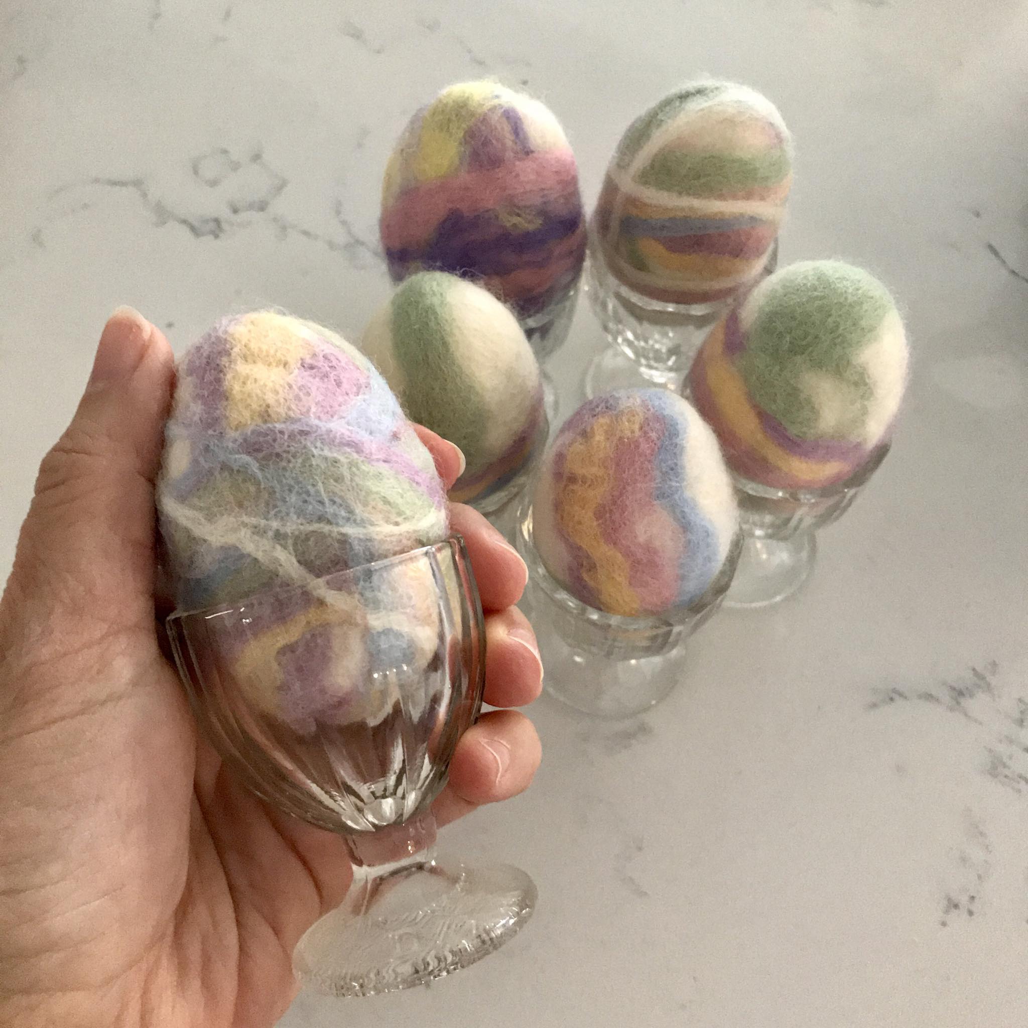 Close-up of the felted soap’s textured surface with colorful wool fibers and delicate Easter egg design detail from a