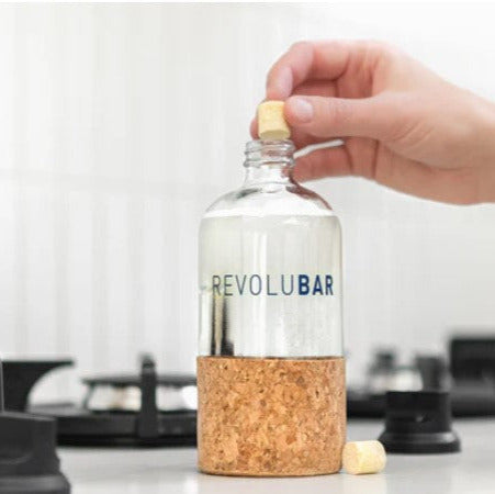 Close-up of the Revolubar cleaner tablet showing textured surface and detailed embossed branding on packaging