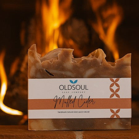 Close-up of the wrapped soap bars with textured natural linen ribbon and festive pinecone accents on the Winter Soap Gift Box