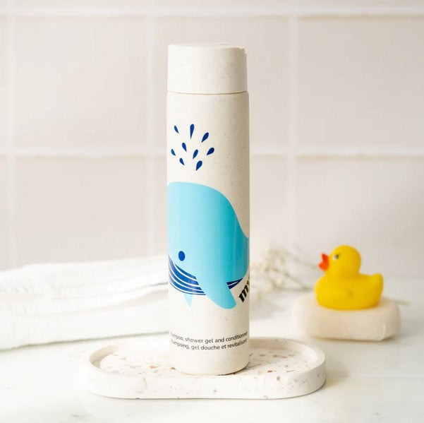 Close-up of the transparent shampoo bottle revealing a gentle, bubbly foam texture with a hint of floral scent and colorful